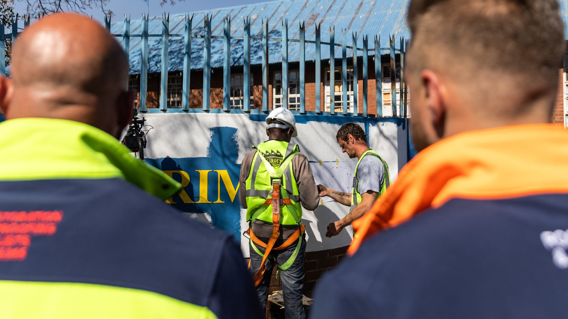 Volunteers in high vis jackets on site at community school