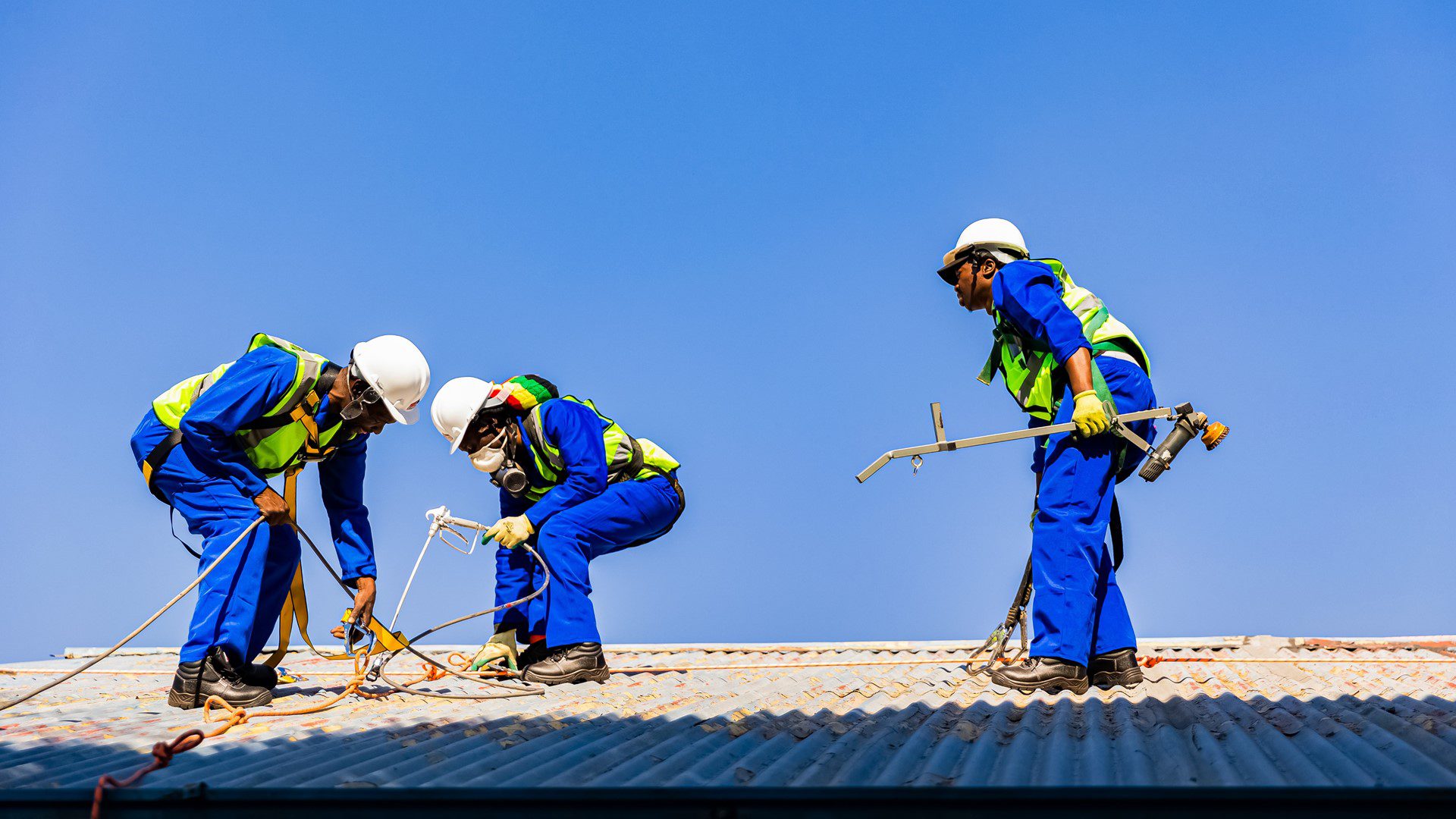Staff repairing roofing on community centre building