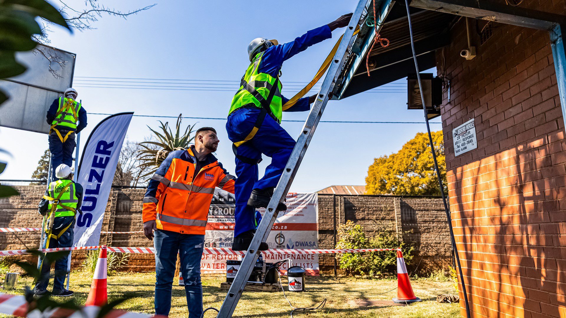 Staff climbing a ladder to repair community roofing as part of CSI