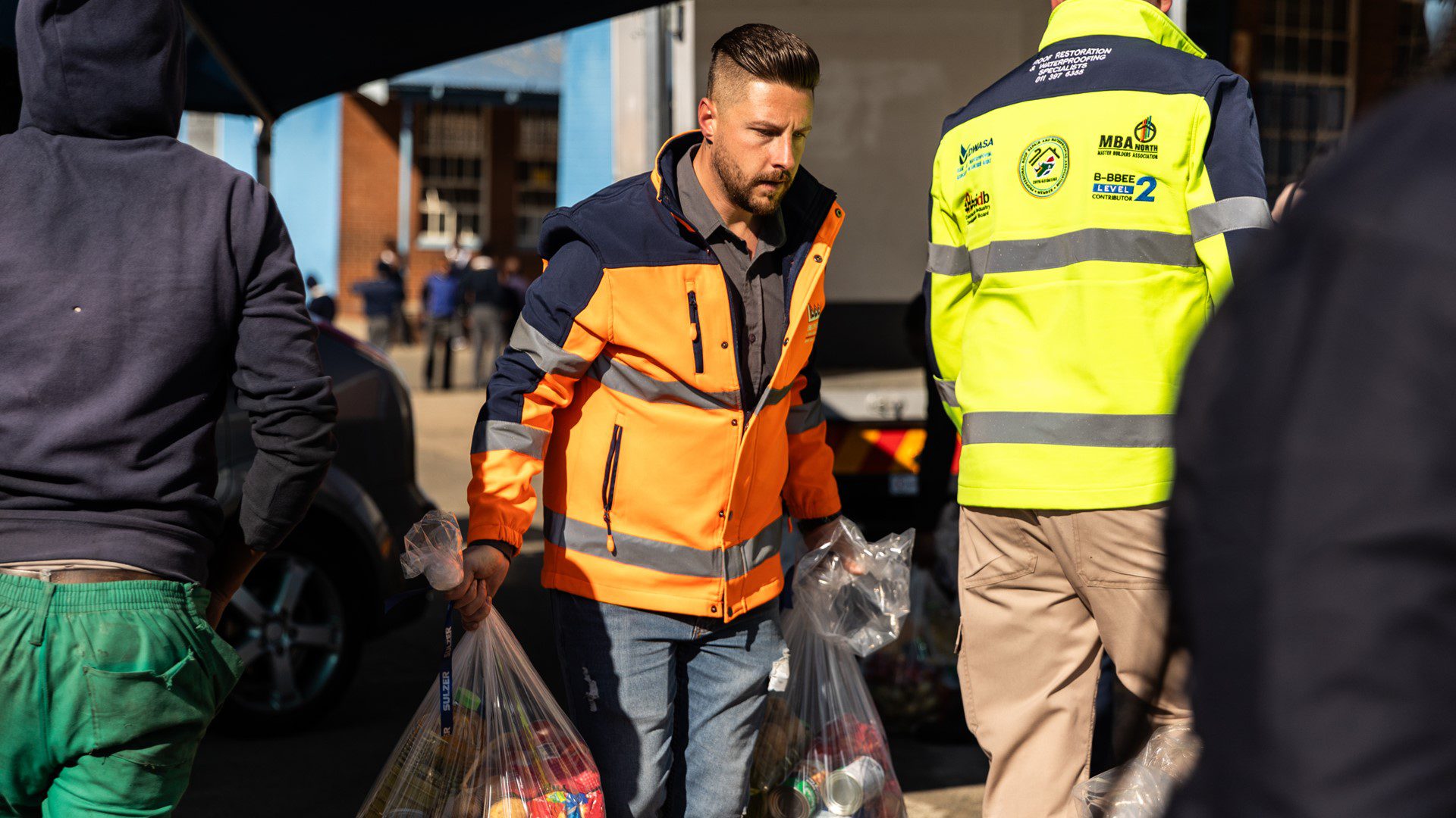 Employee in vest assisting with roofing and food support