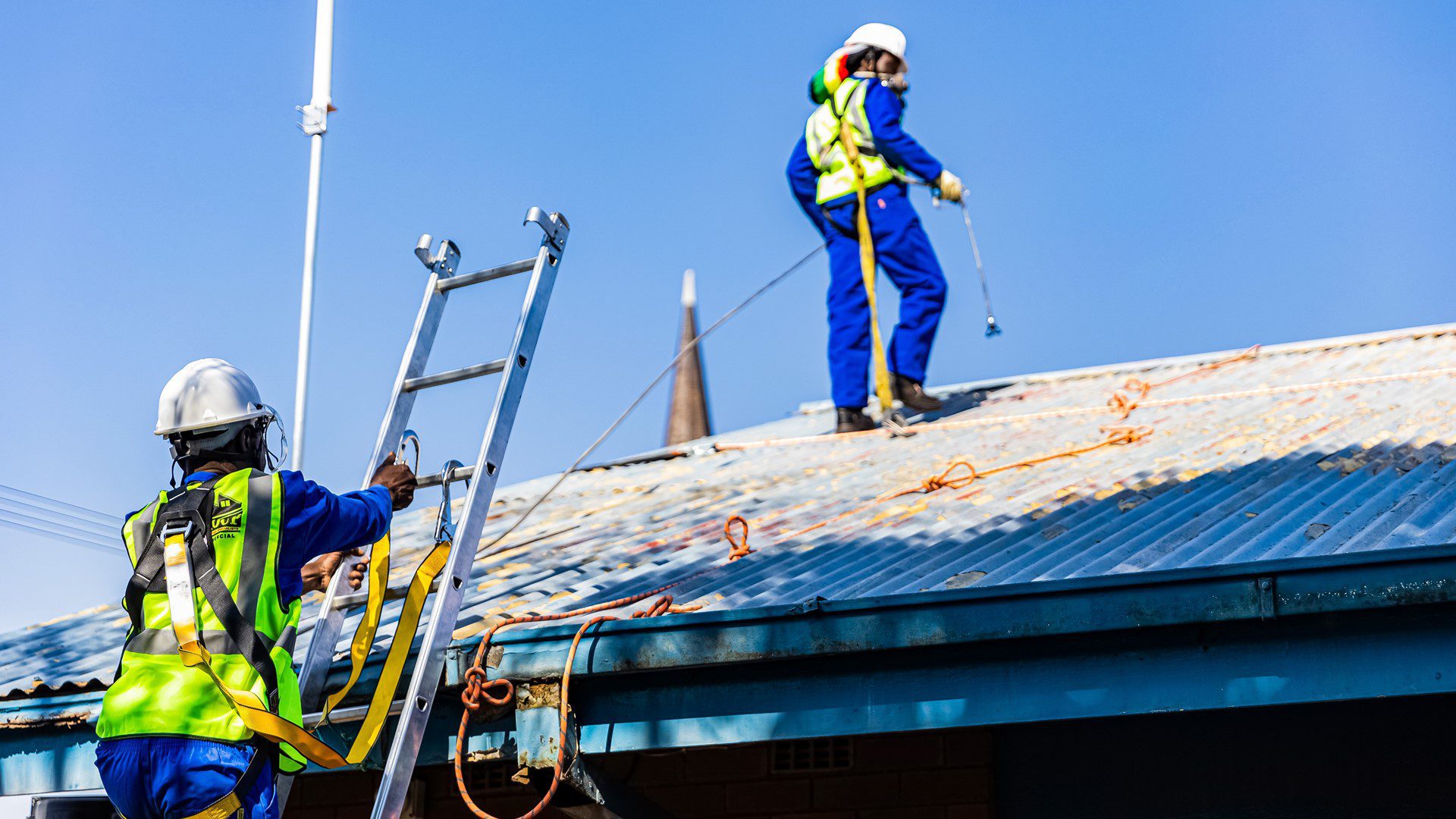 Staff preparing to repair roofing at Ambrose Primary School.