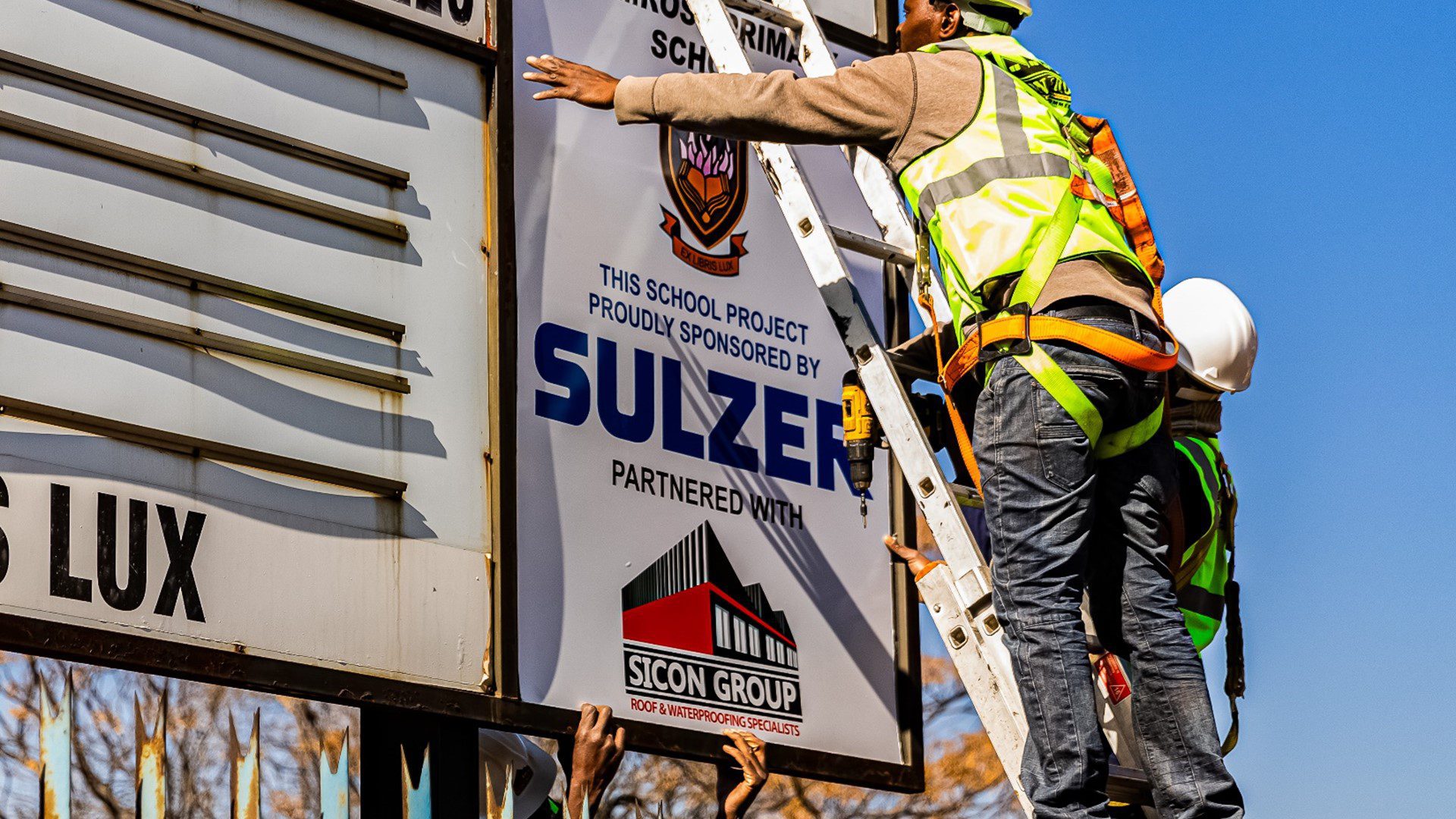 Workers performing restoration on rooftop under clear skies