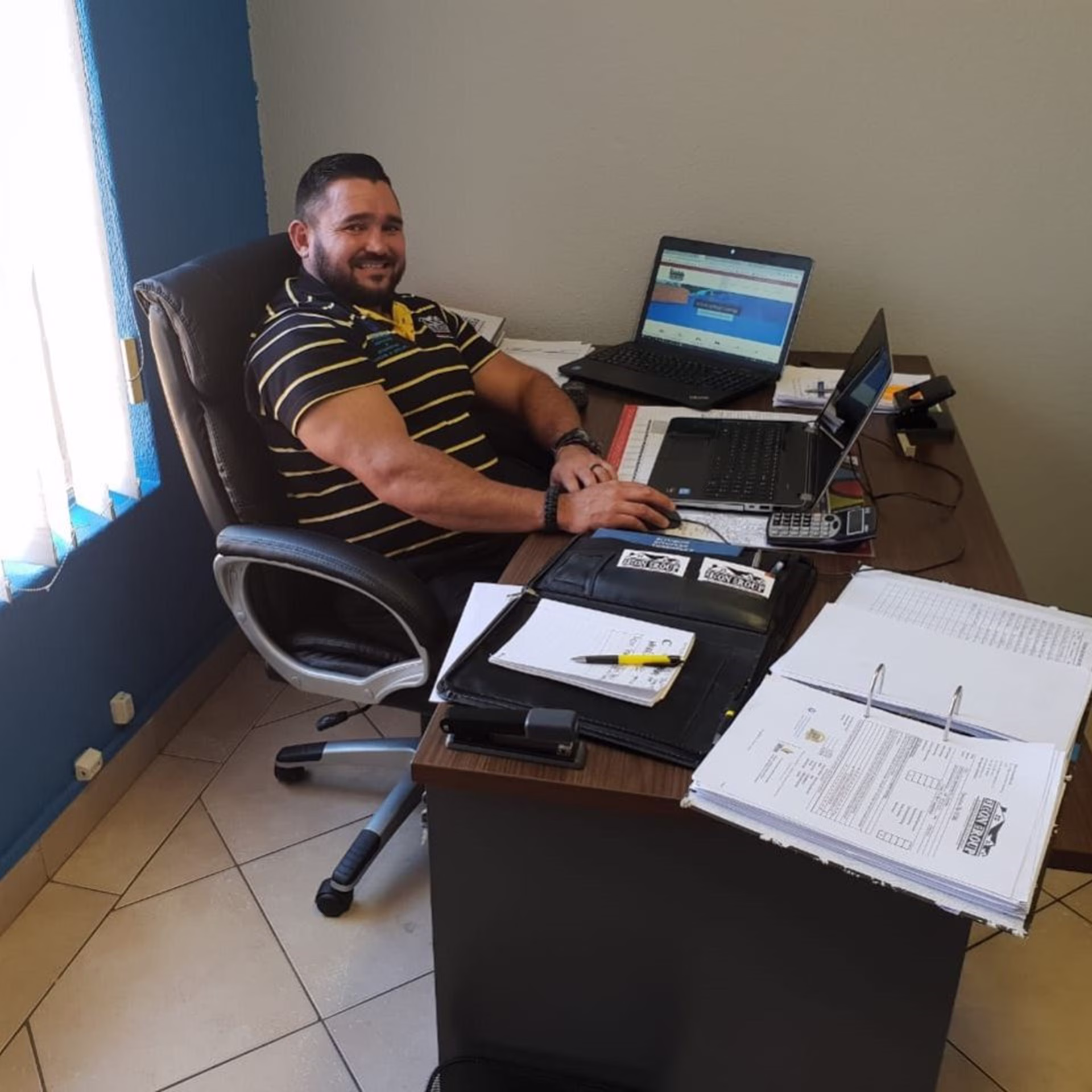 Sicon CEO working at computer station with project documents on desk