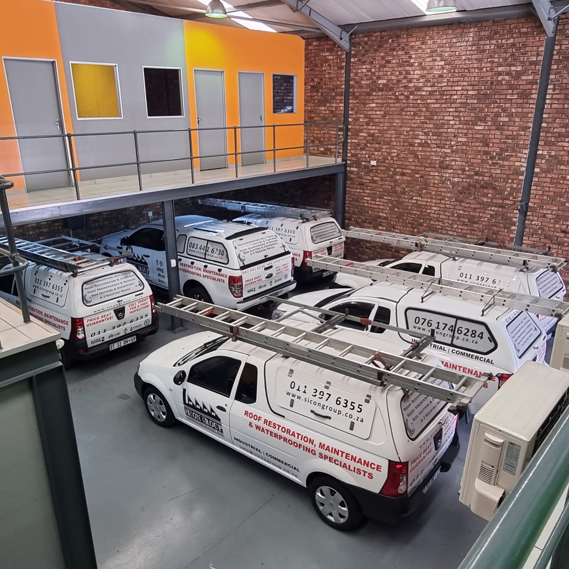 Interior view of Sicon service bay with branded vehicles lined up