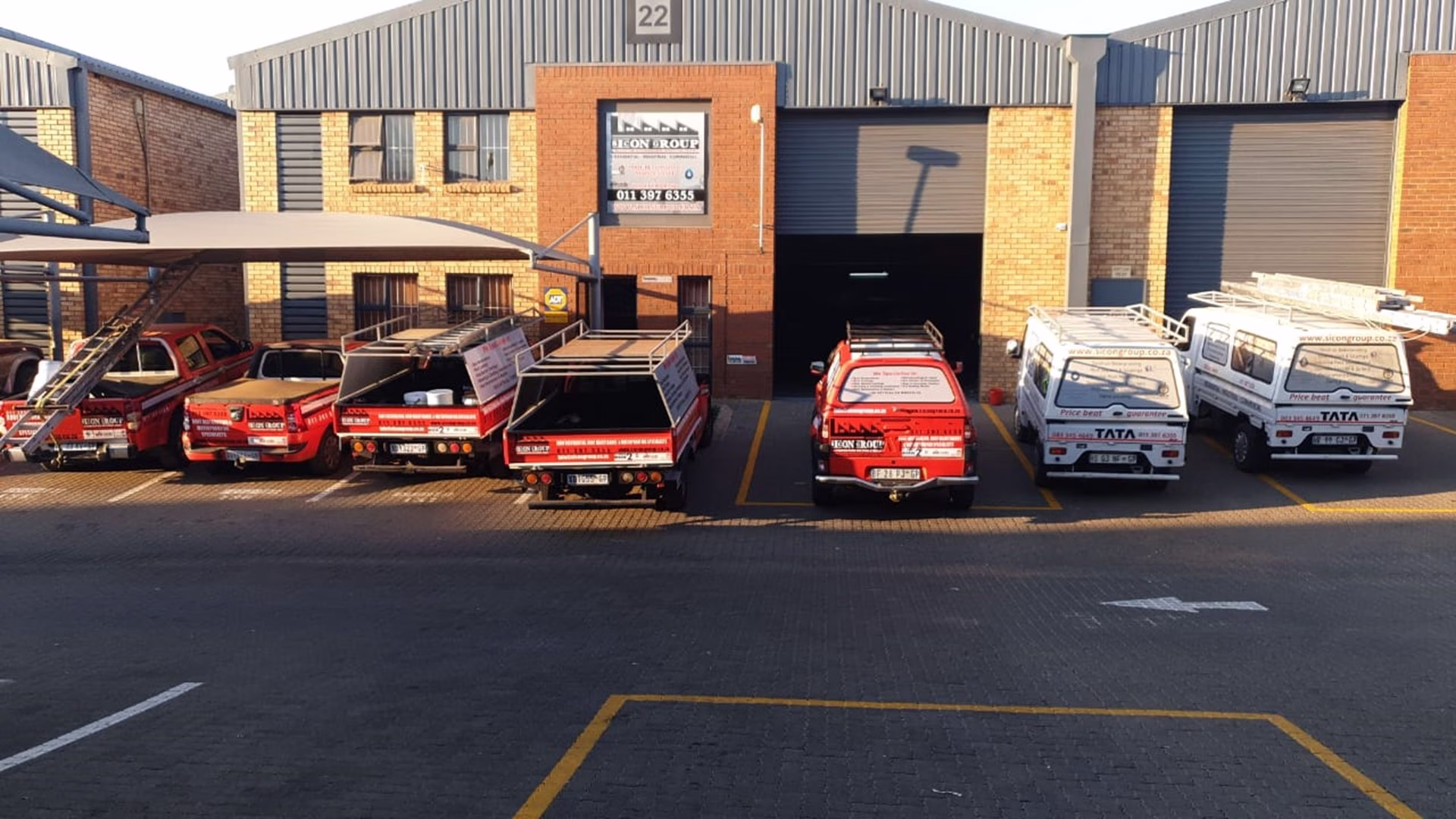 Full line up of Sicon service bakkies and trucks parked in front of company building