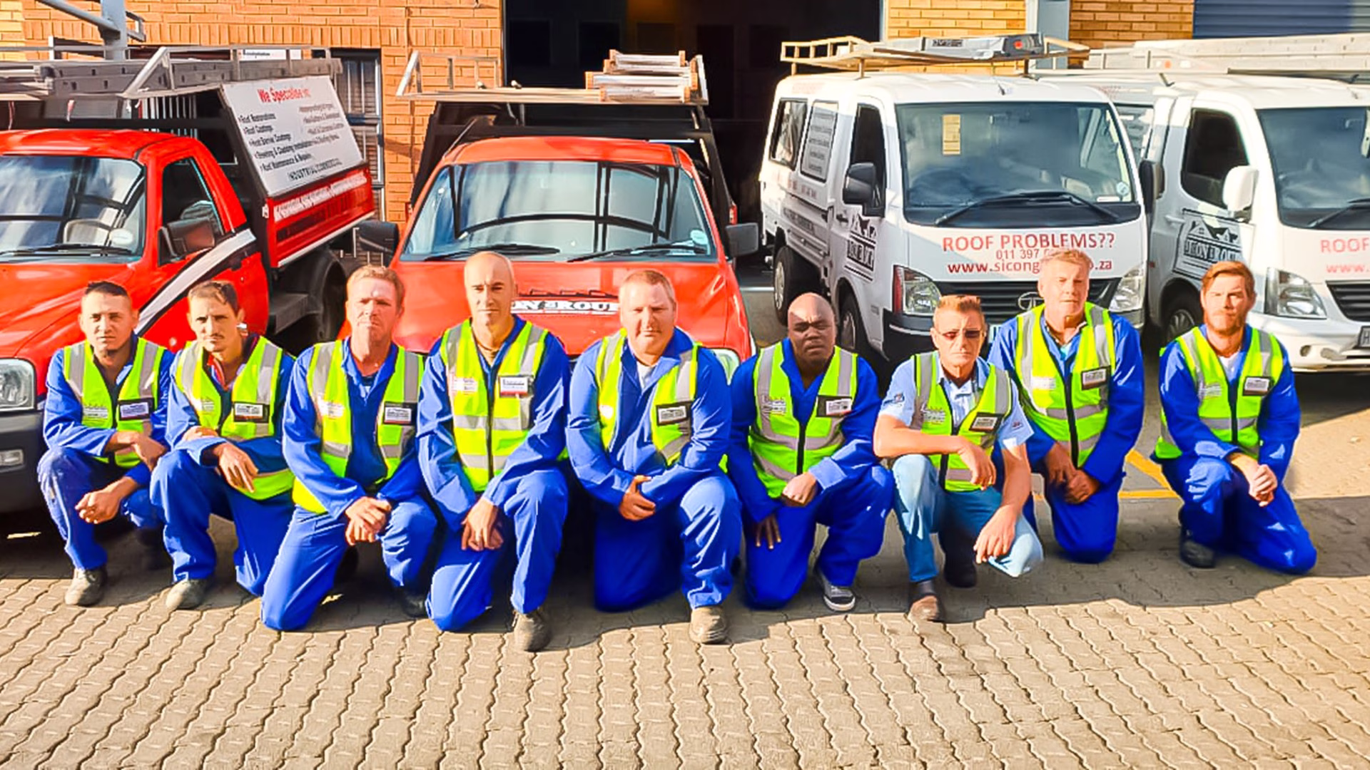 Regional Sicon Group team in uniform gathered for a photo in front of service vehicles