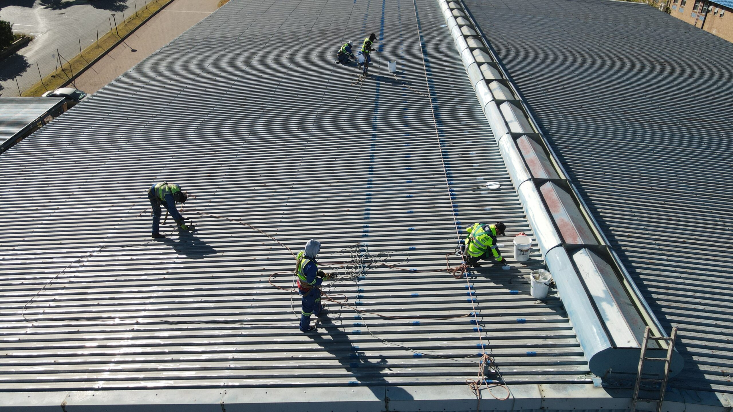 Sicon Group professionals sealing and inspecting a large corrugated metal roof at an industrial property in South Africa as part of scheduled maintenance.