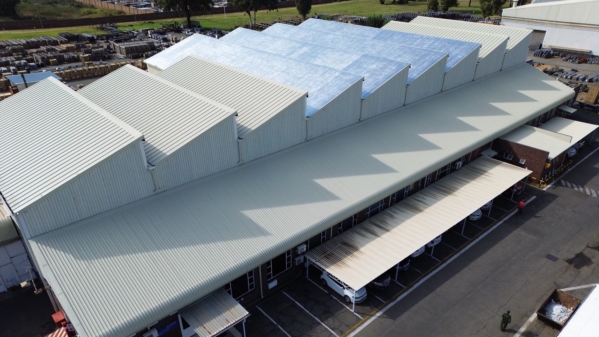 Actom industrial warehouse roof before full restoration with signs of rust and wear.